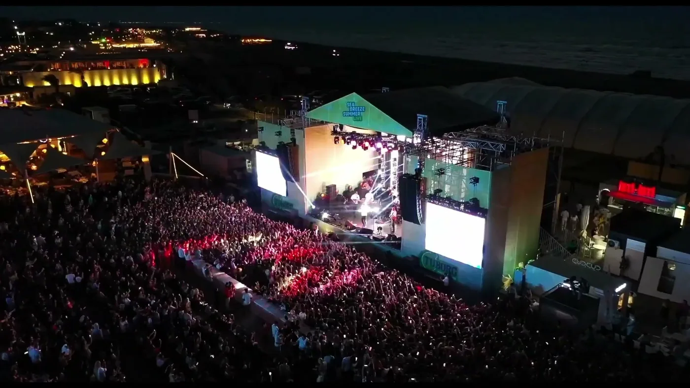 Ночной вид сверху: сцена под навесом с баннером «Sea Breeze Summer Live» и заполненное поле перед ней — кадр летнего концертного сезона, не самого Dream Fest